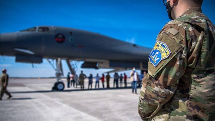 A B-1B Lancer on the ramp with service members and local visitors during Super Bowl LV flyover crew visits