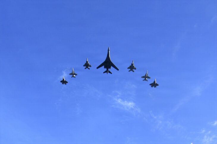 Eight-ship formation led by a B-1B Lancer with F-15C, F/A-18E and F-35C jets flying over Levi's Stadium for Super Bowl LX