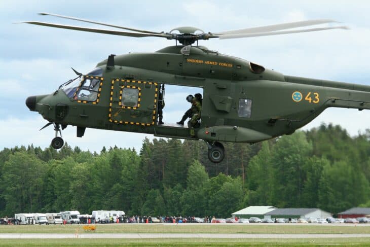 Swedish Armed Forces NH90 Hkp 14A number 43 hovering with a crewman in the door