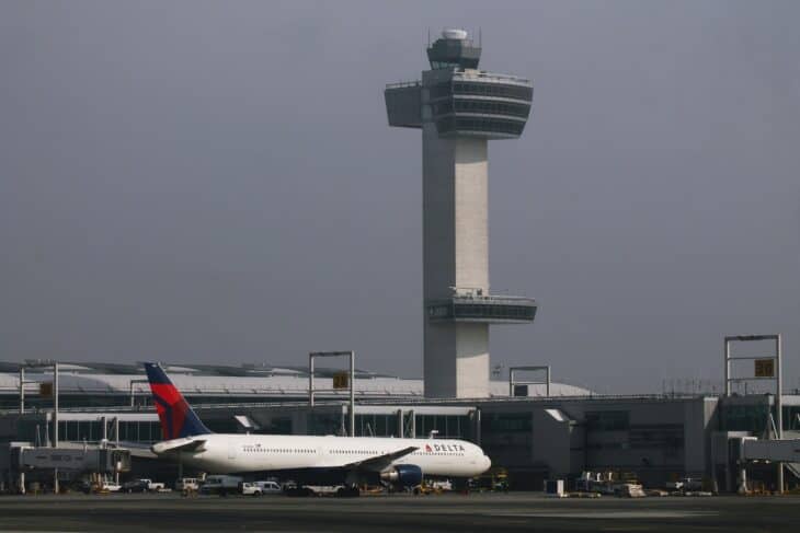Delta Boeing 767-400ER parked at JFK with the airport's control tower behind