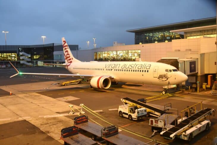 Virgin Australia Boeing 737-800 VH-8VH parked at a Sydney Airport gate at dusk