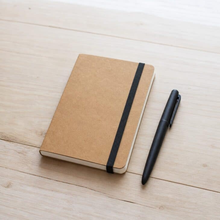Small kraft paper notebook with an elastic band and a pen