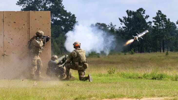 US Army soldiers firing an FGM-148 Javelin with the missile climbing away in a puff of white smoke