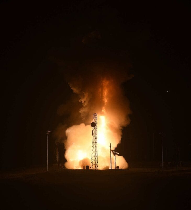 Minuteman III ICBM lifting off from its launch site in a burst of flame at night