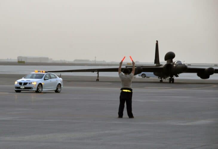 U-2S Dragon Lady taxiing on a runway with a ground crew member signaling in front