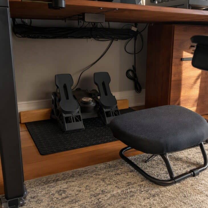 A mat and a wooden stop keep rudder pedals from creeping forward.