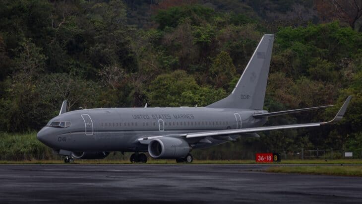 Gray US Marine Corps C-40A Clipper parked on a wet airport apron
