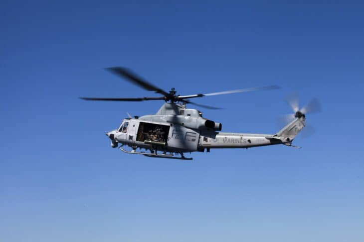 US Marine Corps UH-1Y Venom in flight with crew visible in the open cabin door