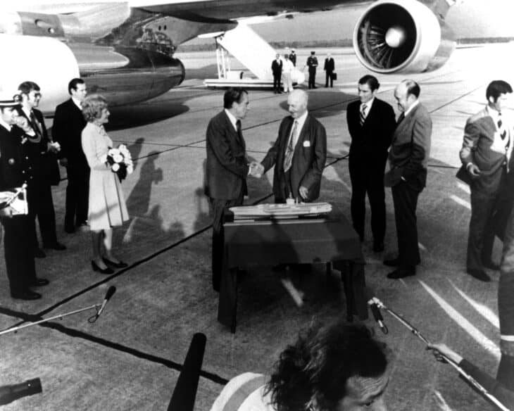 President Richard Nixon shakes hands with former Congressman Carl Vinson beside a model of the carrier that would carry his name