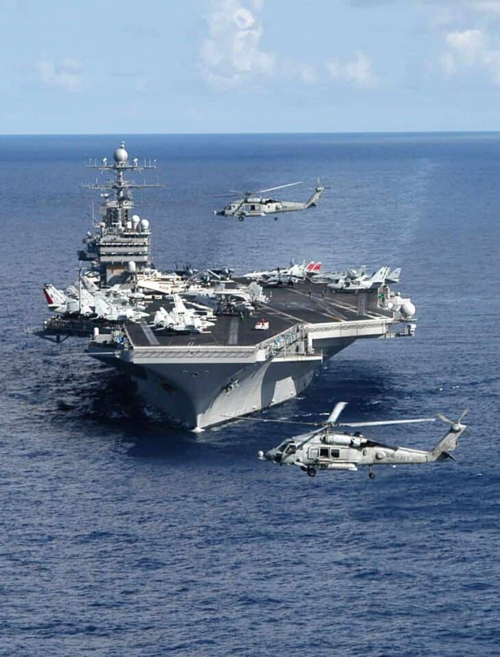 USS Theodore Roosevelt (CVN-71) steaming head-on in the Atlantic with two HH-60H Seahawk helicopters hovering off her bow