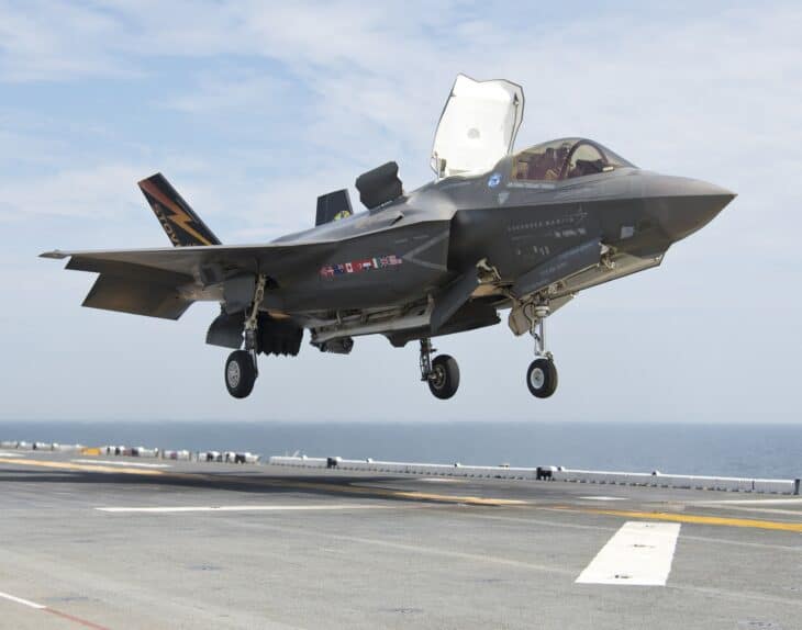 F-35B Lightning II hovering over the flight deck of an amphibious assault ship