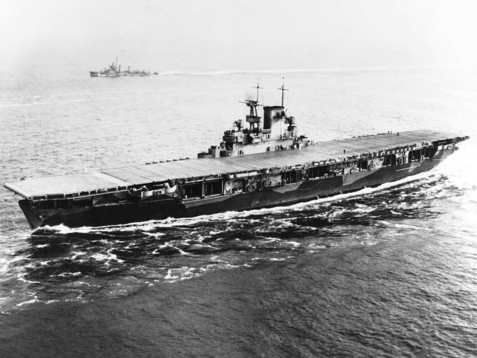 USS Wasp (CV-7) entering Hampton Roads in May 1942 with her flight deck empty and the sea churning at her bow