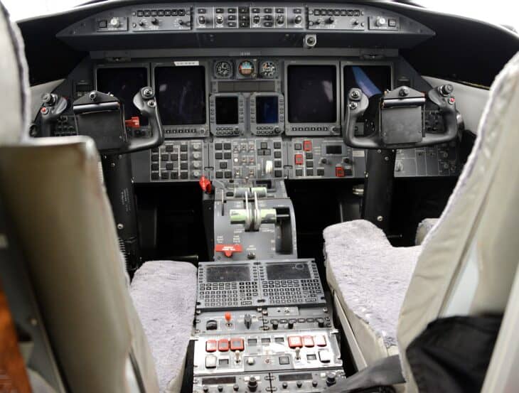 Flight deck of a Bombardier Learjet 45 showing the instrument panel, control yokes and thrust levers