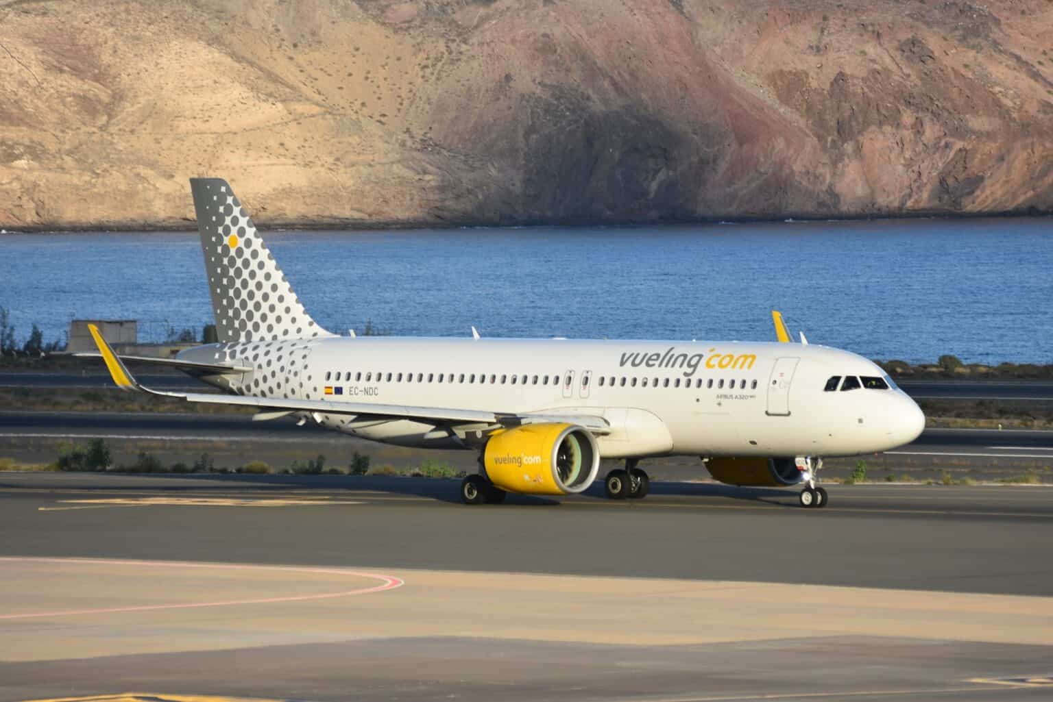 Vueling Airbus A320neo EC-NDC taxiing at Gran Canaria Airport with a rocky hillside behind