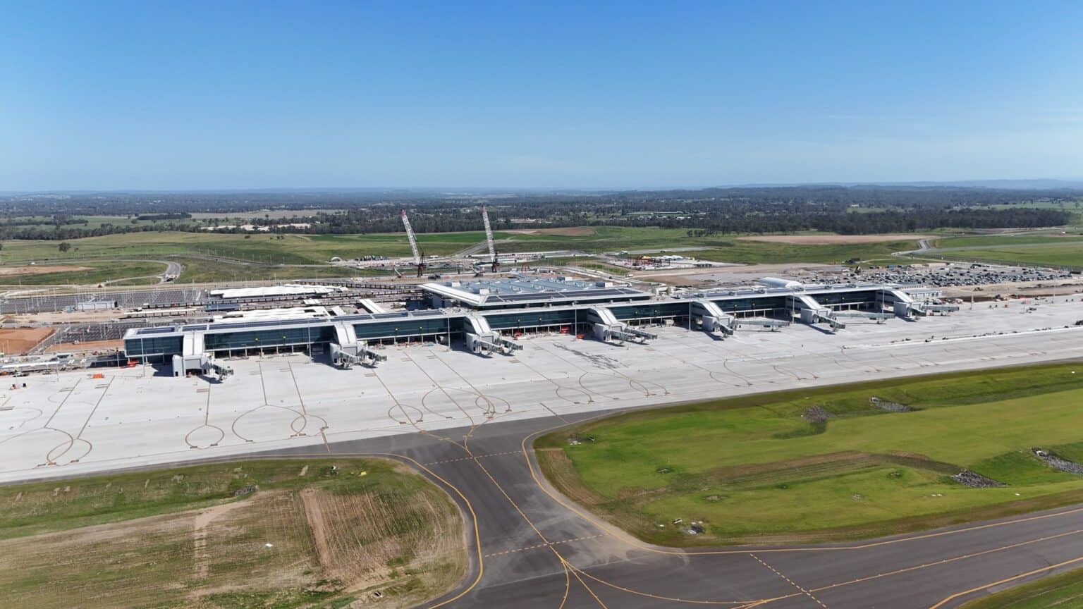 Aerial view of the Western Sydney International Airport terminal and runway apron on a clear day