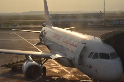 Tunisair Airbus A320 at a boarding bridge at Tunis-Carthage Airport in morning light