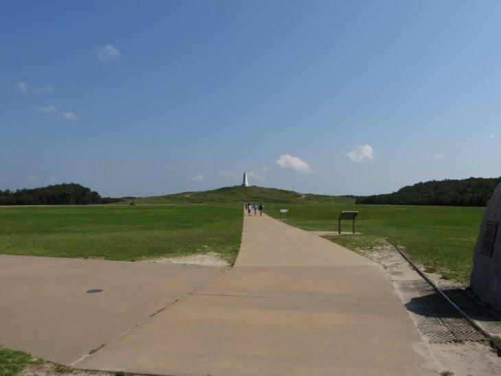 Path across the grass toward the granite Wright Brothers Monument on its hill at the Wright Brothers National Memorial