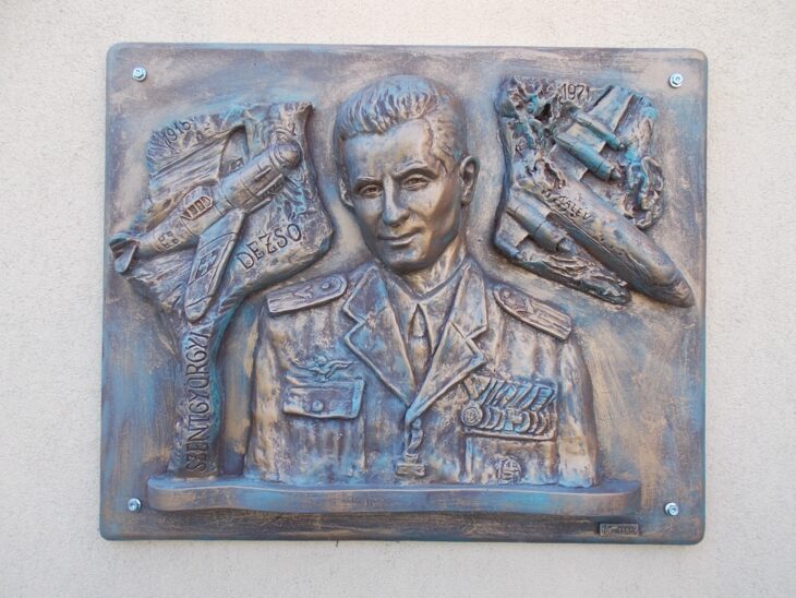 Bronze relief portrait of Dezső Szentgyörgyi flanked by fighter aircraft