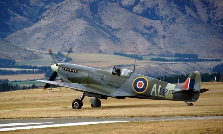 Supermarine Spitfire Mk IX taxiing on an airfield with mountains behind