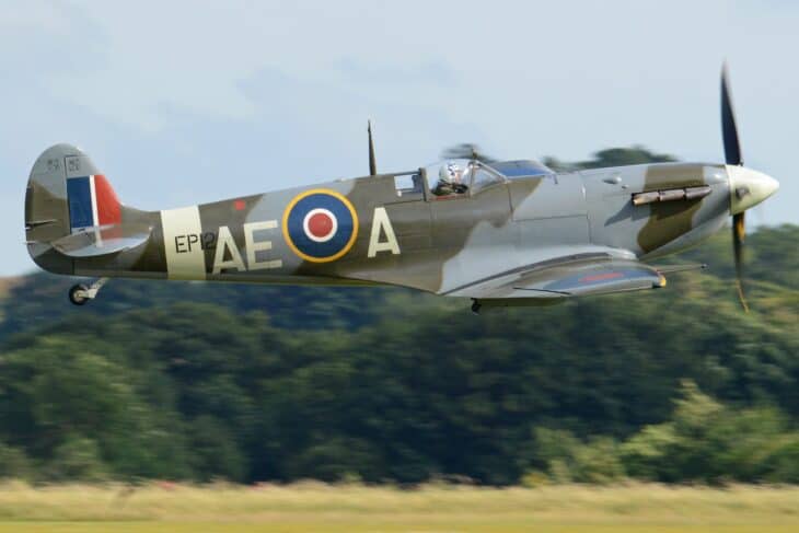 Supermarine Spitfire LF.Vb in RAF markings flying low over a field